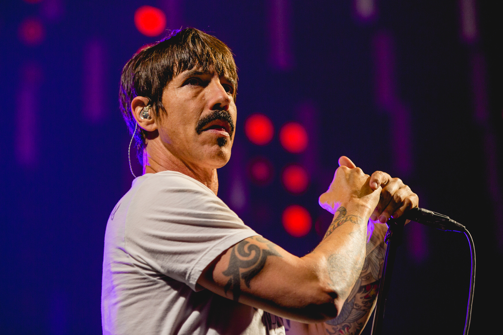 Red Hot Chili Pepper's front man Anthony Kiedis sings in front of a microphone at a concert
