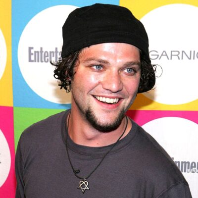 Bam Margera smiles in gray shirt and black beanie