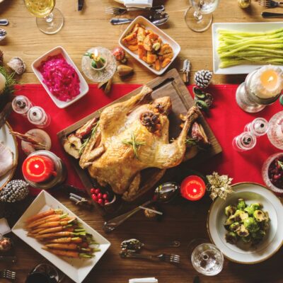 Overhead view of a Christmas dinner table set with a turkey and various sides