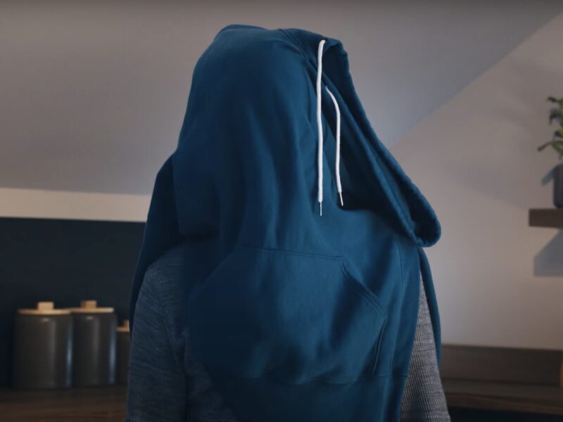screenshot of a man with a blue hoodie draped over his head from a Downy commercial