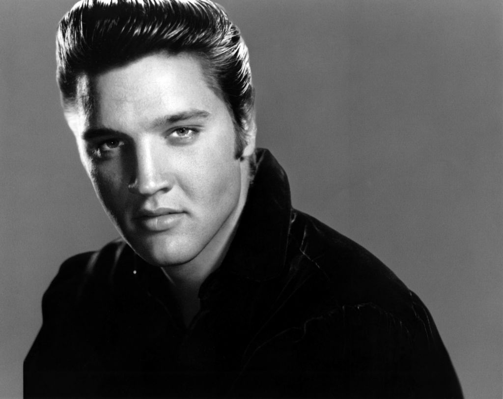 A black and white Iconic image of Elvis Presley posing in a studio