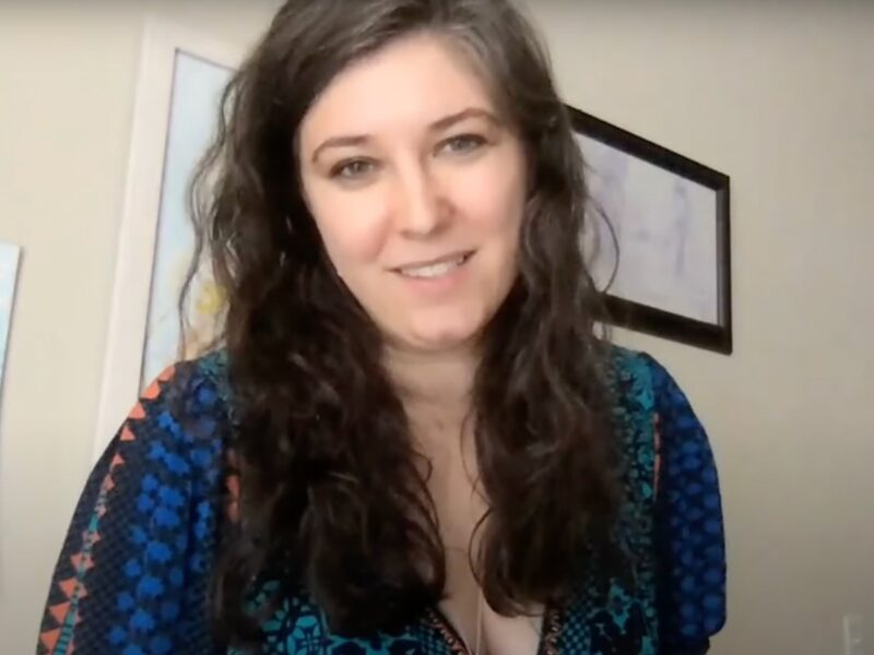 Screenshot of Emily Stern smiling in blue patterned top