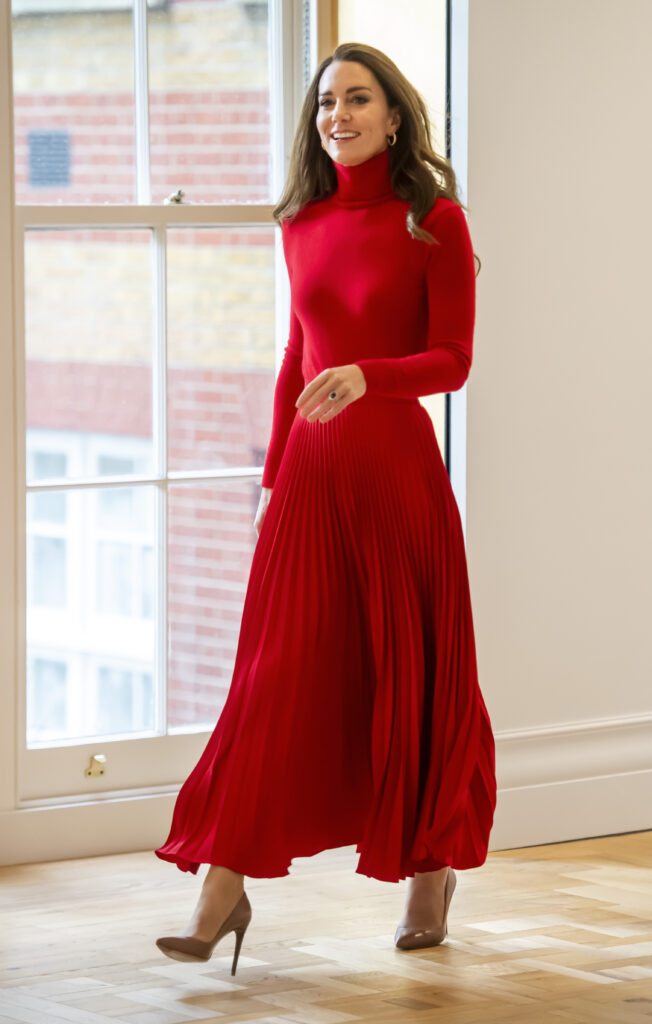Kate Middleton wearing red pleated skirt during her "taking action on addiction" campaign