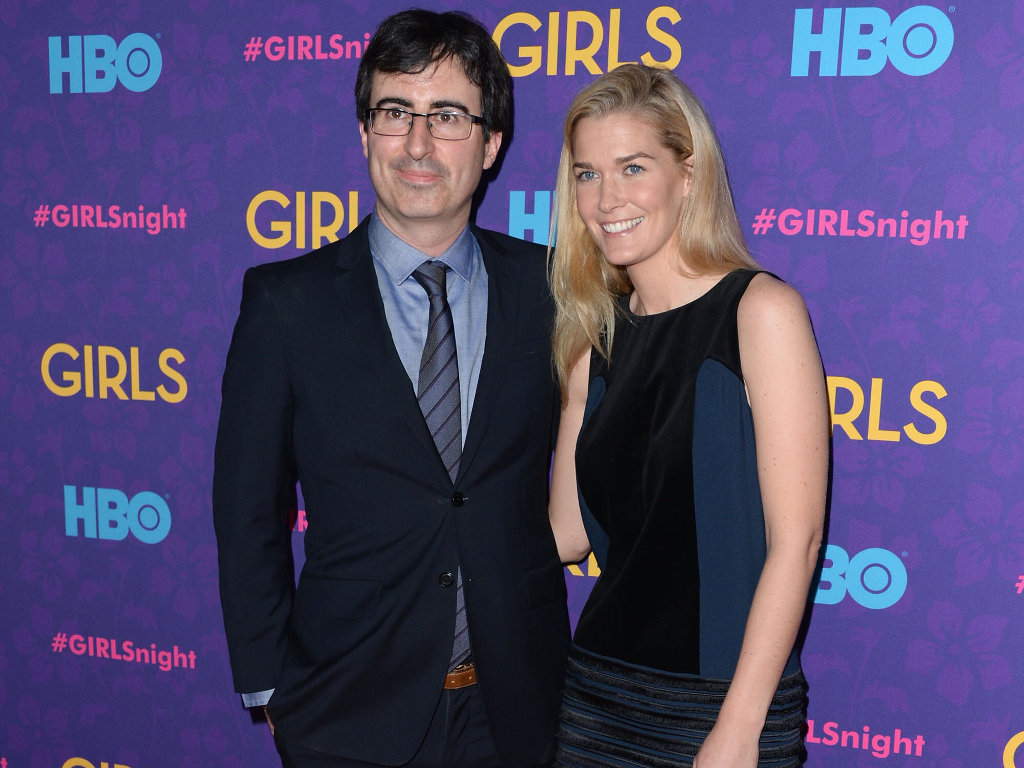 John Oliver (L) and Kate Norley pose against purple backdrop