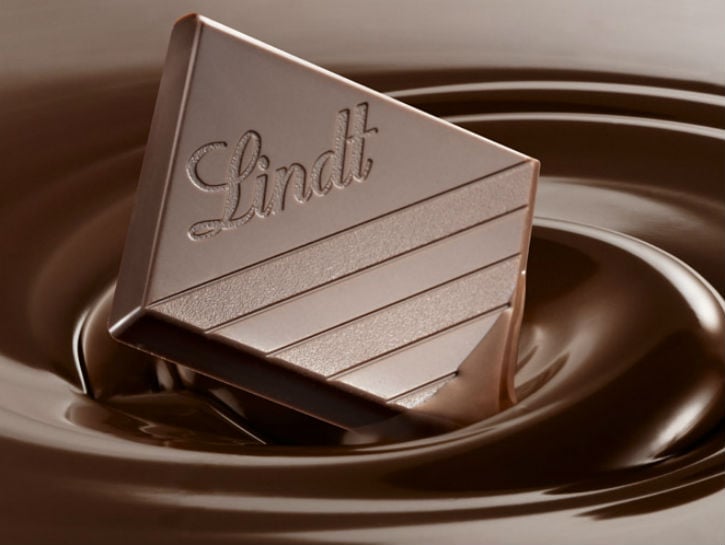 Piece of Lindt chocolate dipped in a pool of liquid chocolate.