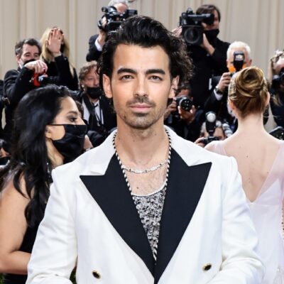 Joe Jonas smiles in white suit with black trim