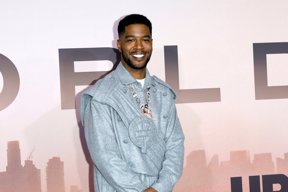 Kid Cudi poses on the red carpet wearing a silver unique suit