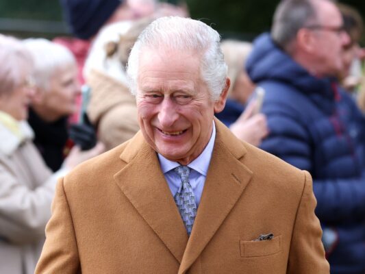 Prince Charles smiles in mustard yellow blazer over blue top