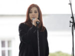 photo of Priscilla Presley speaking into a microphone dressed in black at Lisa Marie's public memorial