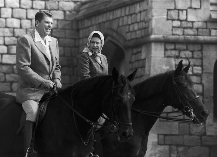 Ronald Reagan and Queen Elizabeth speaking while riding horses