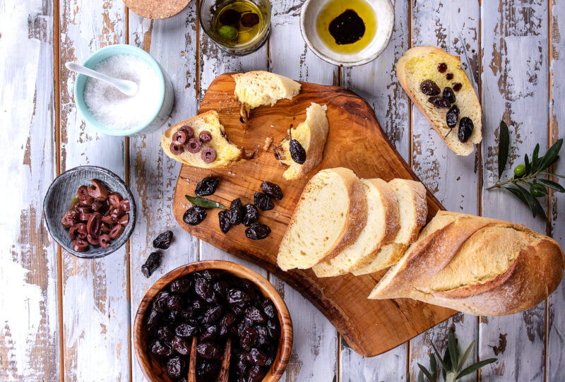 Traditional Greek appetizer of olives with bread on a wooden board