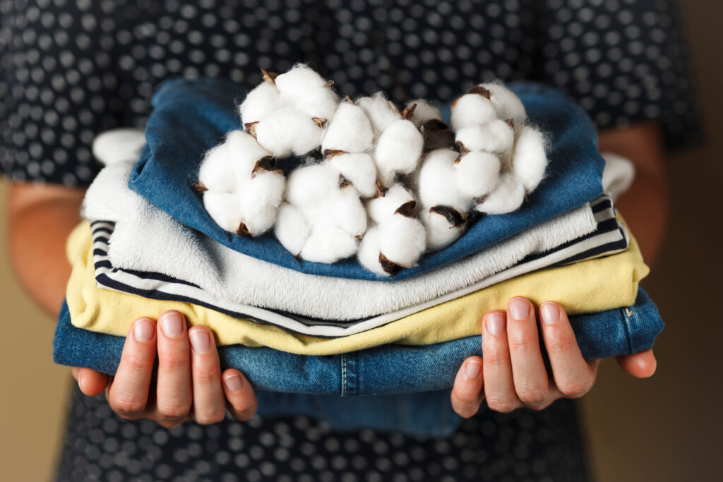 Image of a woman holding clothes with cotton laid on top.