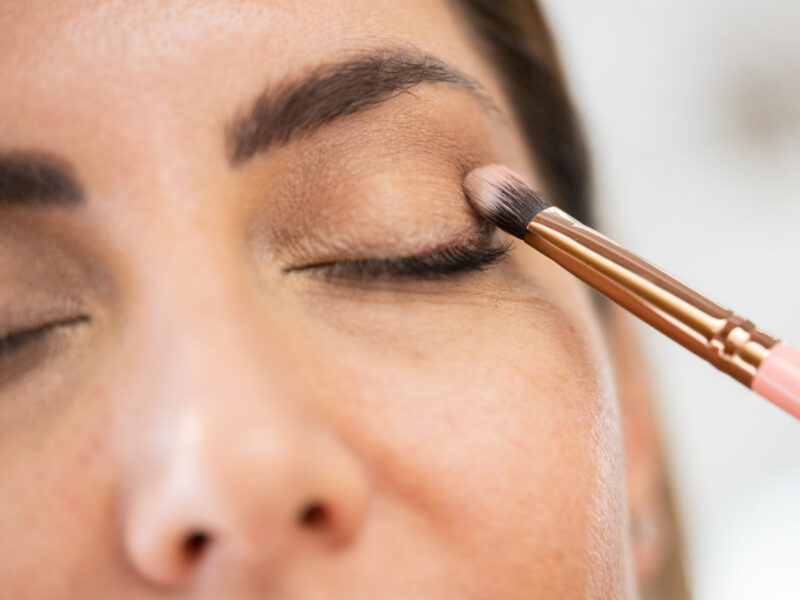 A closeup on a woman having eyeshadow applied