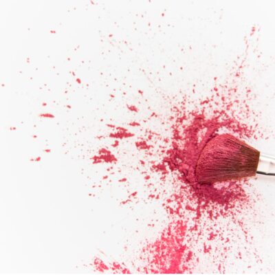 A makeup brush with pink powder blush