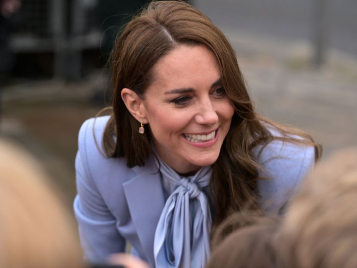 Kate Middleton wearing a periwinkle outfit and a dainty pair of dangly earrings