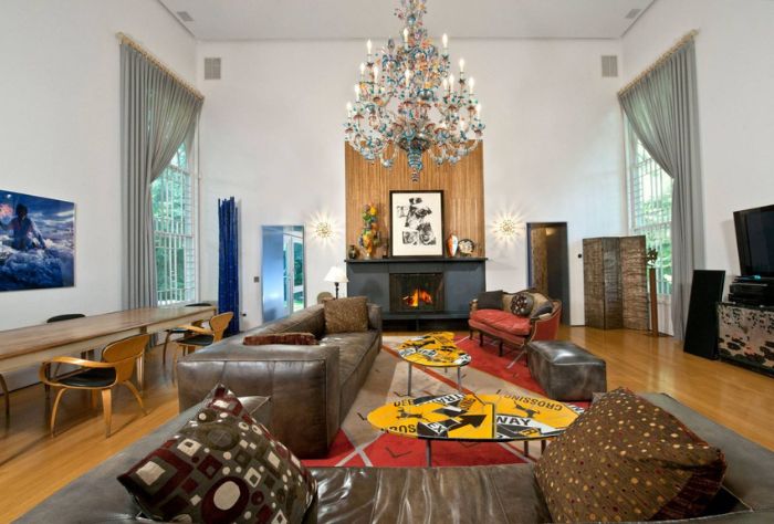 The spacious living room features a modern fireplace and colorful chandelier