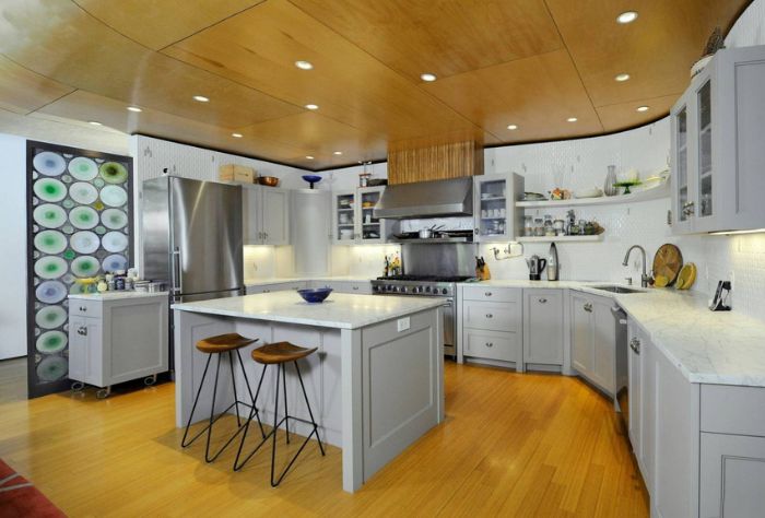 The kitchen mixes cedar floors and ceiling with marble countertops and a decorative glass wall
