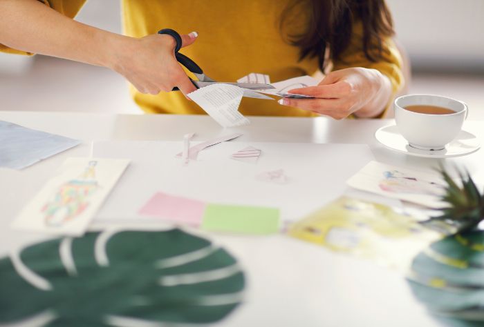 Woman making vision board on table