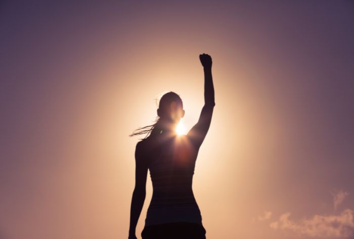 SIlhouette of woman raising fist in the air