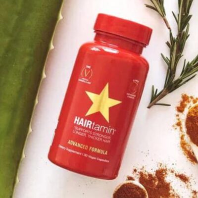HAIRtamin bottle with supplement ingredients around it