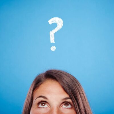 Image of woman from nose up looking up toward white question mark on blue background