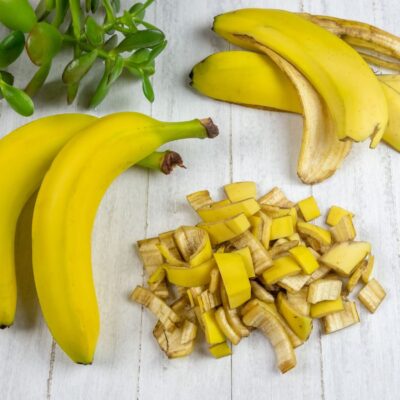 Chopped banana peels next to bananas, whole banana peels