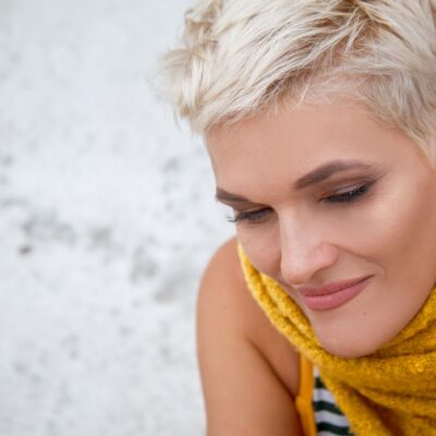 middle aged woman with short platinum hair and smokey eye makeup