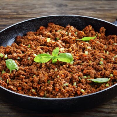Pan of cooked ground beef sprinkled with herbs