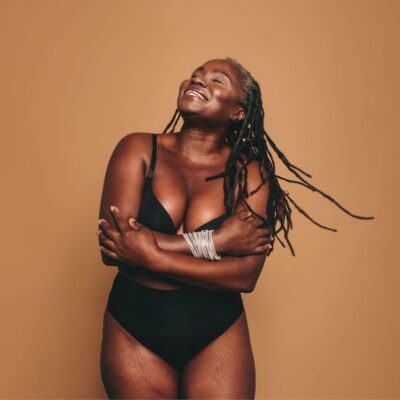 Black woman embracing her curvy figure and smiling