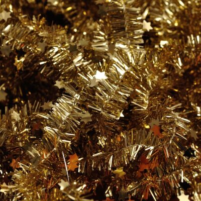 Close-up of gold Christmas tree tinsel with stars interspersed
