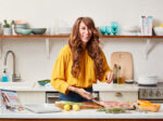 Whole30 founder Melissa Urban smiles and preps food in the kitchen