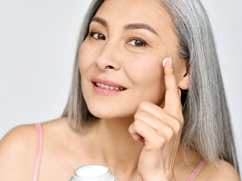 Middle aged woman putting on face cream