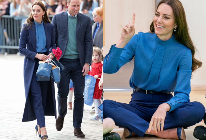 Kate Middleton wearing navy slacks, a cobalt blue blouse, navy pumps, and a navy coat